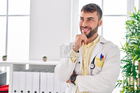 Téléchargez les photos : Young hispanic man wearing doctor uniform speaking at clinic - en image libre de droit