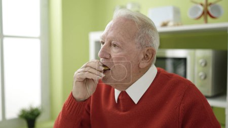 Téléchargez les photos : Seniors manger des cookies à la maison - en image libre de droit