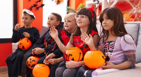 Téléchargez les photos : Groupe d'enfants portant un costume d'Halloween disant bonjour avec la main à la maison - en image libre de droit