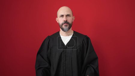 Photo for Young bald man wearing costume standing over isolated red background - Royalty Free Image