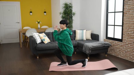 Photo for Young chinese woman training yoga exercise standing at home - Royalty Free Image