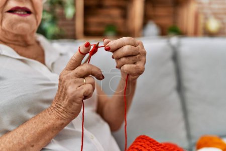 Photo for Senior grey-haired woman smiling confident sewing using lane and needle at home - Royalty Free Image