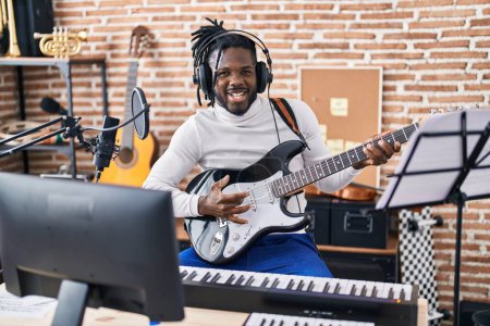 Téléchargez les photos : Artiste afro-américaine chantant une chanson jouant de la guitare électrique au studio de musique - en image libre de droit