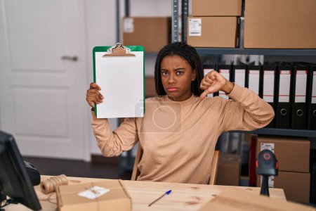Photo for Young african american with braids working at small business ecommerce showing clipboard with angry face, negative sign showing dislike with thumbs down, rejection concept - Royalty Free Image