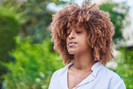 Foto de Mujer afroamericana respirando con los ojos cerrados en el parque - Imagen libre de derechos