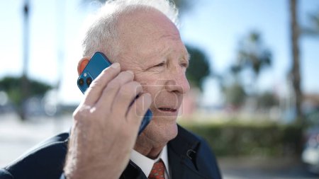 Téléchargez les photos : Senior parlant au téléphone dans la rue - en image libre de droit