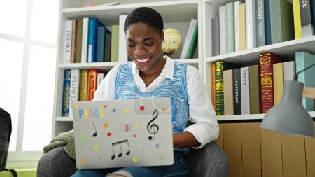 Foto de Estudiante afroamericana usando laptop estudiando en la universidad de la biblioteca - Imagen libre de derechos