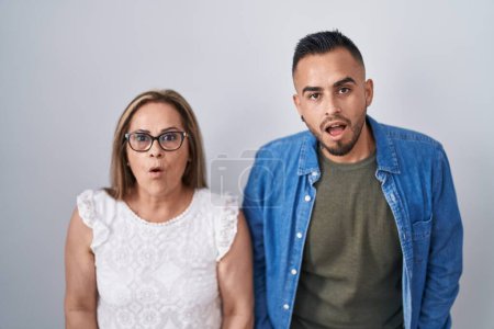 Photo for Hispanic mother and son standing together afraid and shocked with surprise and amazed expression, fear and excited face. - Royalty Free Image