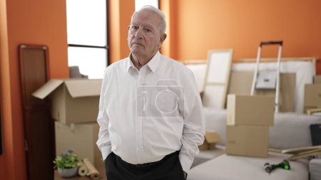Photo for Senior standing with serious expression at new home - Royalty Free Image