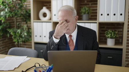 Foto de Trabajador de negocios mayor cansado de trabajar con el ordenador portátil en la oficina - Imagen libre de derechos
