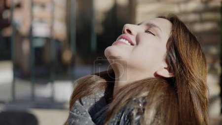 Foto de Young beautiful hispanic woman breathing with closed eyes at street - Imagen libre de derechos