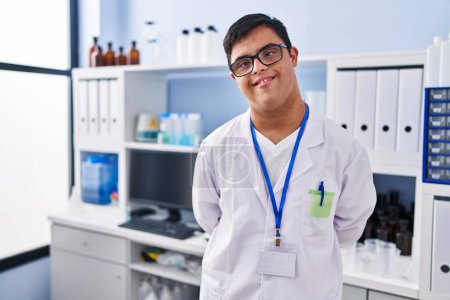 Téléchargez les photos : Homme trisomique portant l'uniforme scientifique debout au laboratoire - en image libre de droit