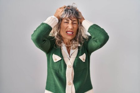 Photo for Middle age woman standing over white background suffering from headache desperate and stressed because pain and migraine. hands on head. - Royalty Free Image