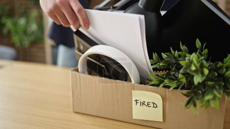 Téléchargez les photos : Jeune homme arabe travailleur d'affaires sans emploi mettre des documents sur la boîte en carton au bureau - en image libre de droit