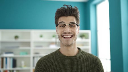 Téléchargez les photos : Young hispanic man student smiling confident standing at library university - en image libre de droit