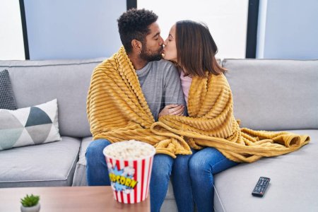 Téléchargez les photos : Man and woman couple watching movie sitting on sofa at home - en image libre de droit