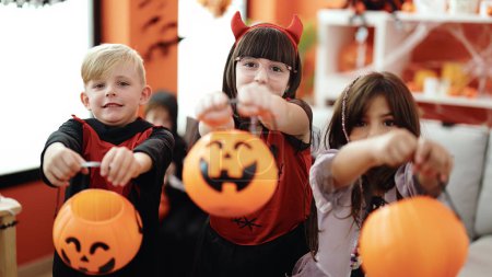 Foto de Grupo de niños con disfraz de Halloween pidiendo caramelos en casa - Imagen libre de derechos