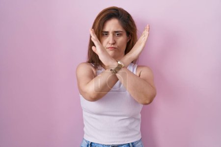 Téléchargez les photos : Femme brune debout sur fond rose expression de rejet croisant les bras faisant signe négatif, visage en colère - en image libre de droit