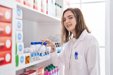 Photo for Young woman pharmacist organize shelving at pharmacy - Royalty Free Image