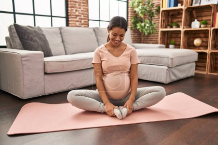 Photo for Young latin woman pregnant smiling confident stretching at home - Royalty Free Image
