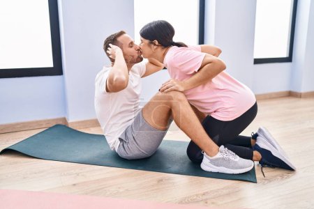 Foto de Hombre y mujer pareja entrenamiento abs ejercicio y besos en el centro deportivo - Imagen libre de derechos