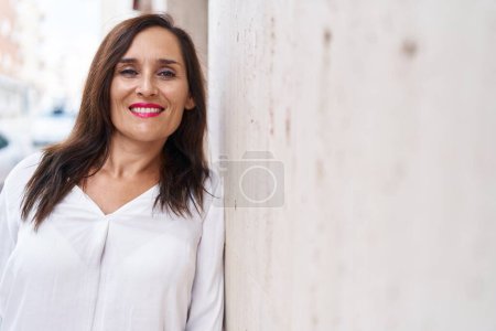 Téléchargez les photos : Jeune belle femme hispanique souriant confiance debout à la rue - en image libre de droit