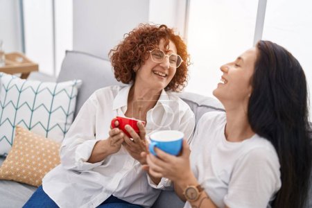 Photo for Two women mother and daughter drinking coffee at home - Royalty Free Image