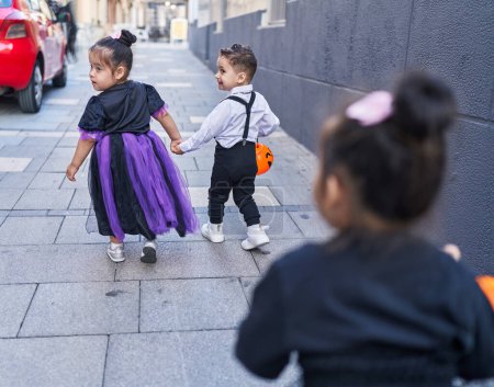 Foto de Grupo de niños con disfraz de Halloween caminando con las manos juntas en el aula - Imagen libre de derechos
