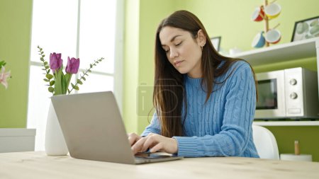 Photo for Young caucasian woman using laptop sitting on table at dinning room - Royalty Free Image