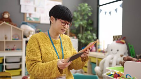 Téléchargez les photos : Jeune enseignante chinoise en maternelle ayant une leçon de vocabulaire à la maternelle - en image libre de droit