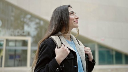 Téléchargez les photos : Jeune belle hispanique femme étudiante souriant confiance debout à la rue - en image libre de droit