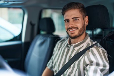 Téléchargez les photos : Jeune homme caucasien souriant confiant portant la ceinture de voiture à la rue - en image libre de droit