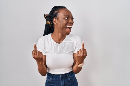 Foto de Beautiful black woman standing over isolated background showing middle finger doing fuck you bad expression, provocation and rude attitude. screaming excited - Imagen libre de derechos