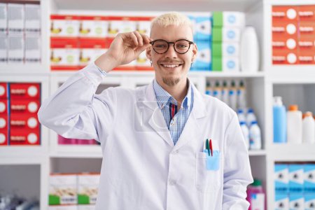 Téléchargez les photos : Young caucasian man pharmacist smiling confident standing at pharmacy - en image libre de droit