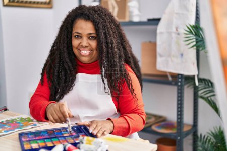 Foto de Mujer afroamericana artista sonriendo dibujo confiado en portátil en el estudio de arte - Imagen libre de derechos