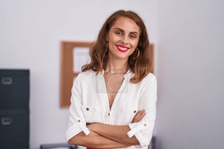 Téléchargez les photos : Jeune belle hispanique femme d'affaires travailleur souriant confiance debout avec les bras croisés geste au bureau - en image libre de droit