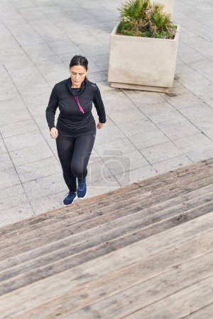 Photo for Young hispanic woman wearing sportswear running at street - Royalty Free Image