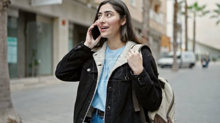 Foto de Young beautiful hispanic woman student smiling confident talking on smartphone at street - Imagen libre de derechos