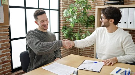 Photo for Two men business partners shake hands at office - Royalty Free Image