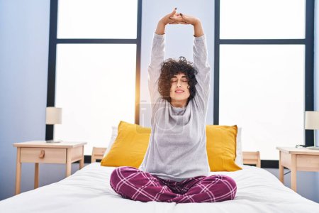 Photo for Young middle east woman stretching arms waking up at bedroom - Royalty Free Image