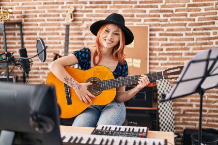 Photo for Young caucasian woman musician playing classical guitar at music studio - Royalty Free Image