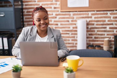Téléchargez les photos : Femme afro-américaine travailleur d'affaires en utilisant un ordinateur portable travaillant au bureau - en image libre de droit