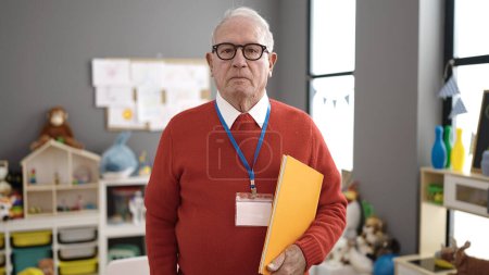 Téléchargez les photos : Professeur préscolaire senior avec le visage en colère à la maternelle - en image libre de droit
