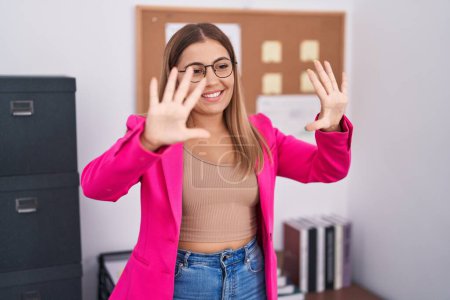 Photo for Young blonde woman standing at the office showing and pointing up with fingers number ten while smiling confident and happy. - Royalty Free Image