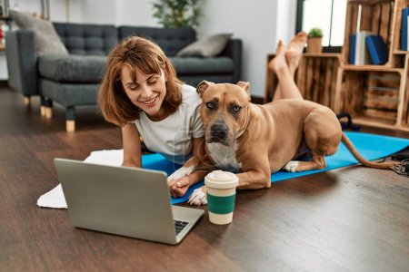 Photo for Young caucasian woman sportswoman smiling confident using laptop with dog at home - Royalty Free Image