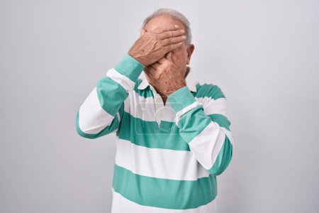 Photo for Senior man with grey hair standing over white background covering eyes and mouth with hands, surprised and shocked. hiding emotion - Royalty Free Image