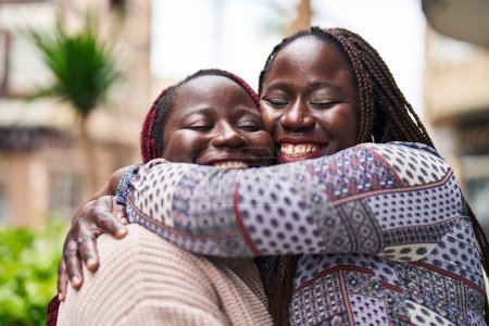 Foto de African american women friends smiling confident hugging each other at street - Imagen libre de derechos