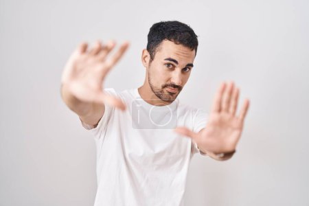 Téléchargez les photos : Bel homme hispanique debout sur fond blanc faisant cadre à l'aide de mains paumes et doigts, perspective de la caméra - en image libre de droit