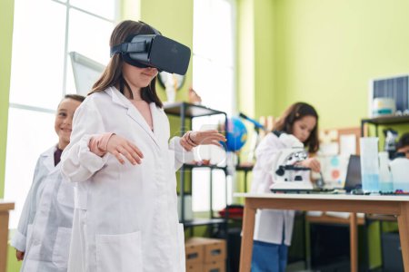 Foto de Grupo de niños estudiantes que usan gafas de realidad virtual en el aula de laboratorio - Imagen libre de derechos