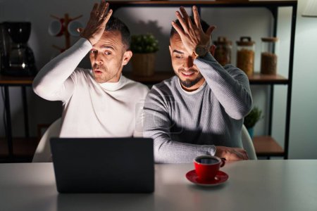 Téléchargez les photos : Couple homosexuel utilisant ordinateur portable surpris avec la main sur la tête pour erreur, rappelez-vous erreur. oublié, mauvais concept de mémoire. - en image libre de droit